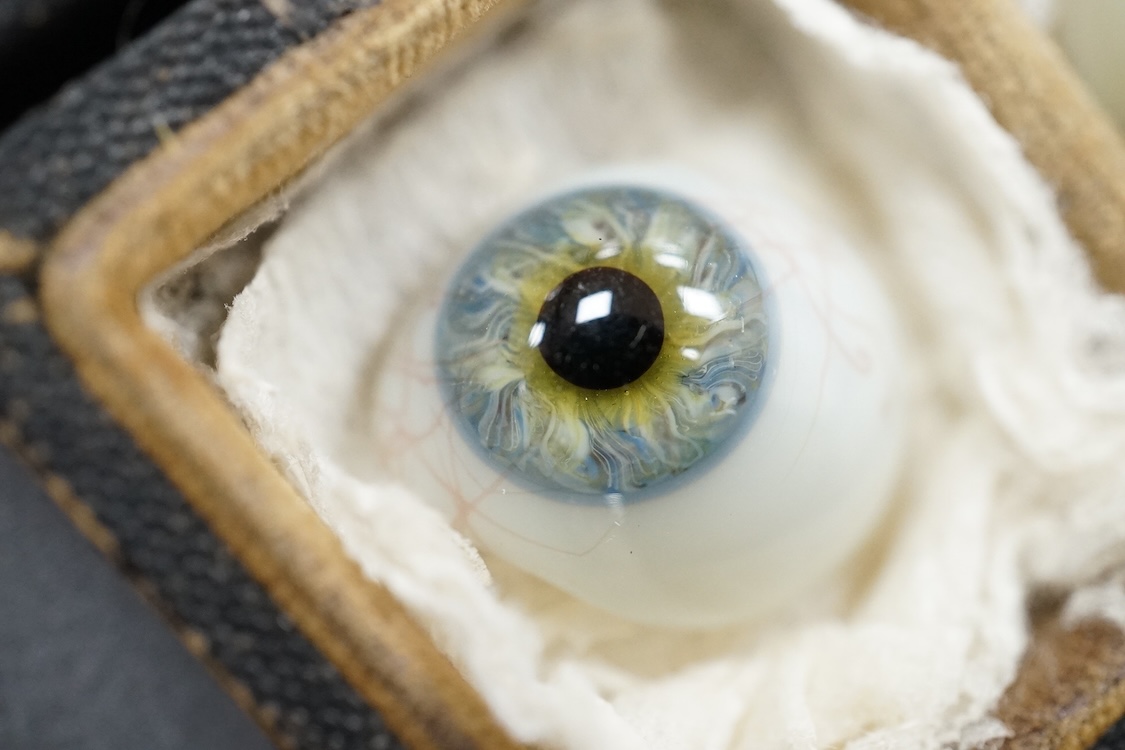 A late 19th century cased group of three prosthetic glass eyes